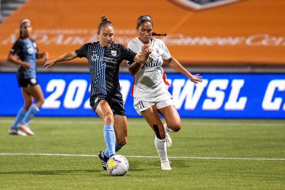 NWSL defenders fight for the ball. 